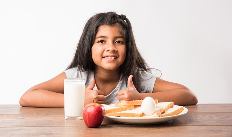 girl-having-milk-apple-egg-bread